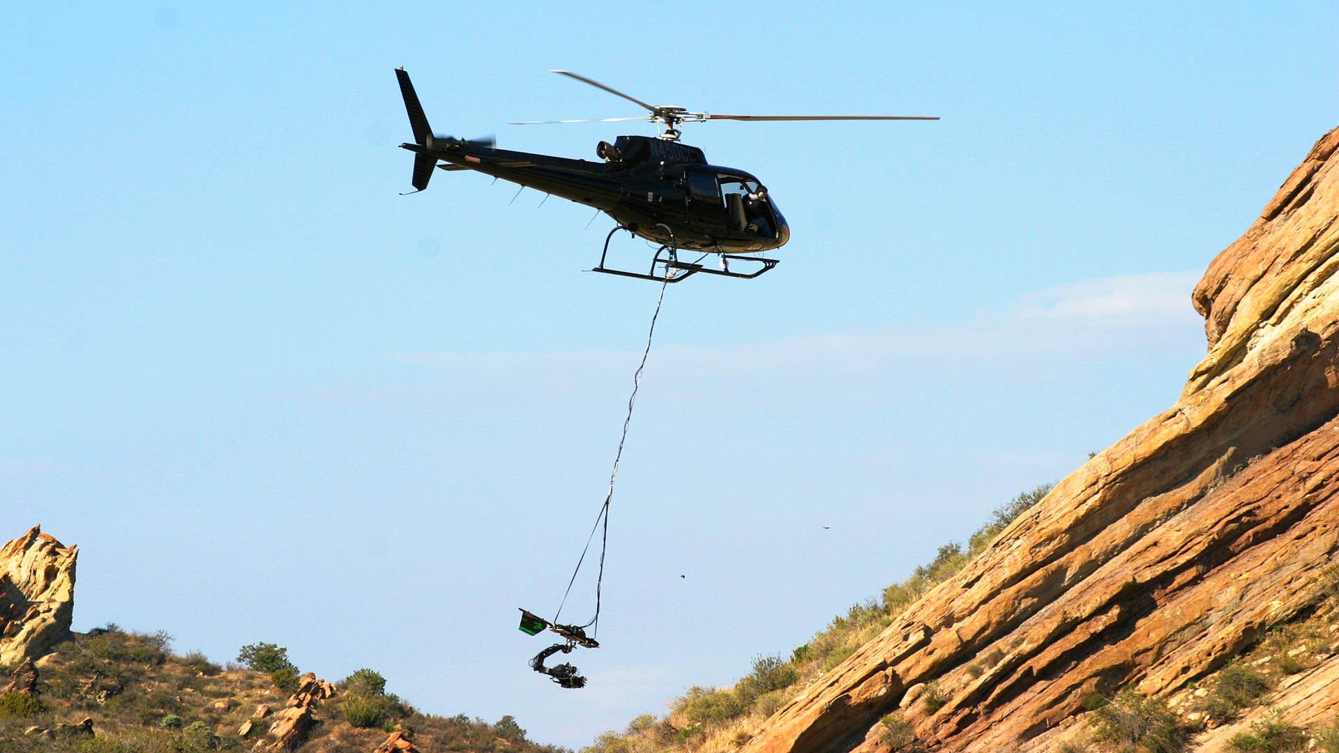Helicopter long-line suspended camera system skimming water surface